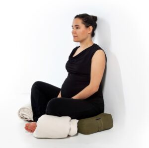 Woman sitting in meditation with yoga props